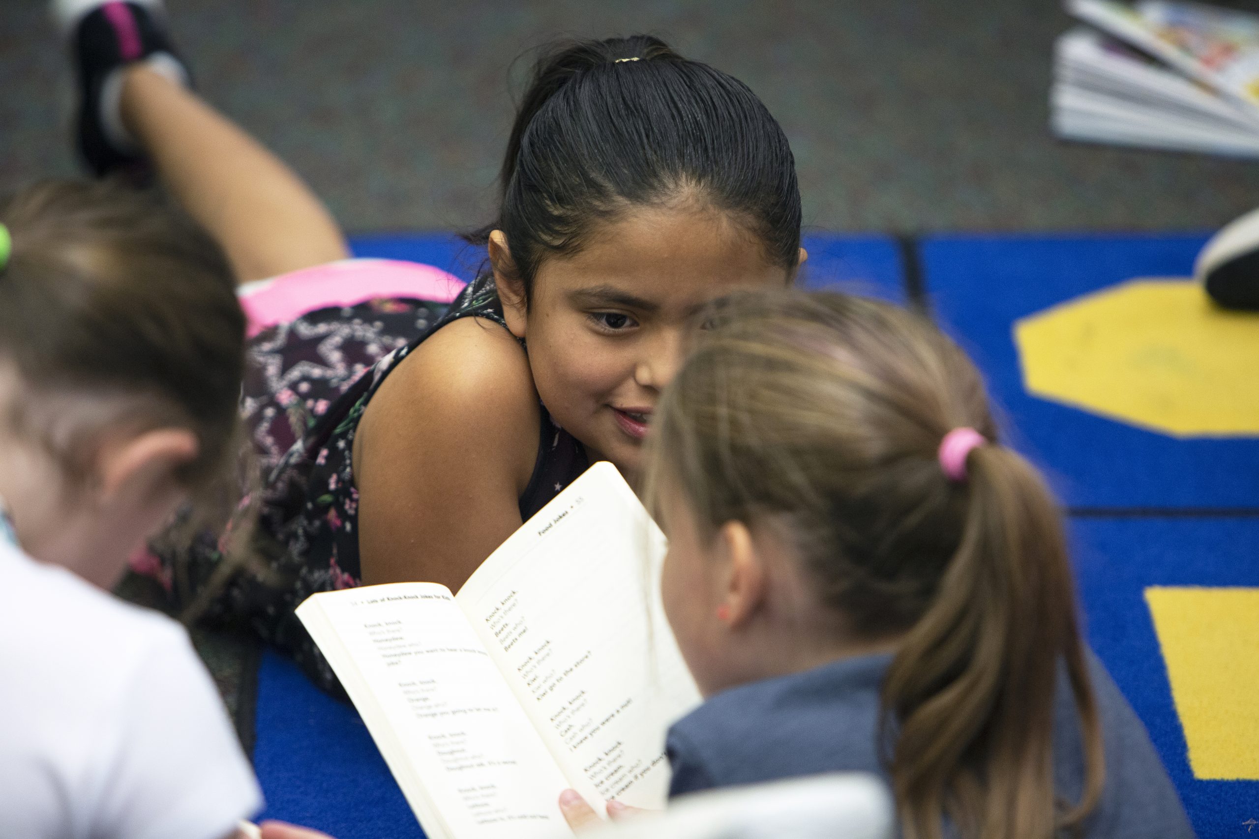 students on a carpet reading