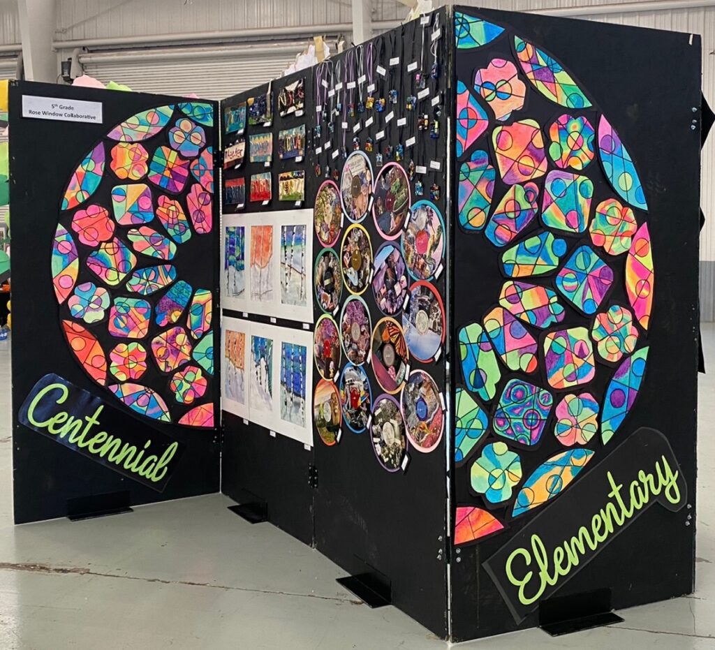 Art display featuring colorful stained glass designs labeled "Centennial Elementary" and framed student artwork.