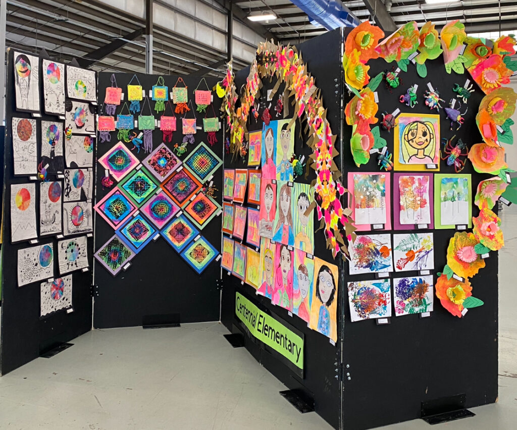 Art display showcasing colorful student artworks and crafts in a school setting, labeled "Centennial Elementary."