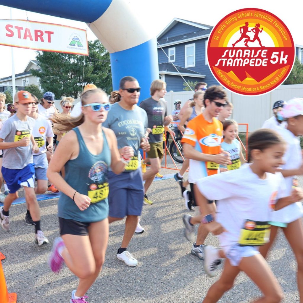 Corredores de distintas edades participan en una carrera de 5 km, que comienza bajo un gran arco con el letrero «START».